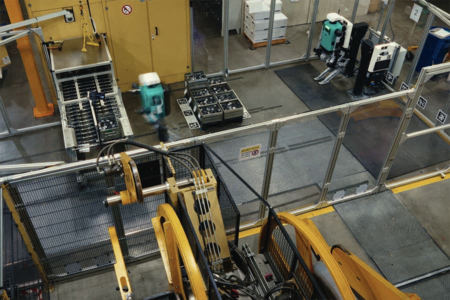 Industriehalle mit Transportbändern und einem humanoiden Roboter in Betrieb (Foto: Agility Robotics)