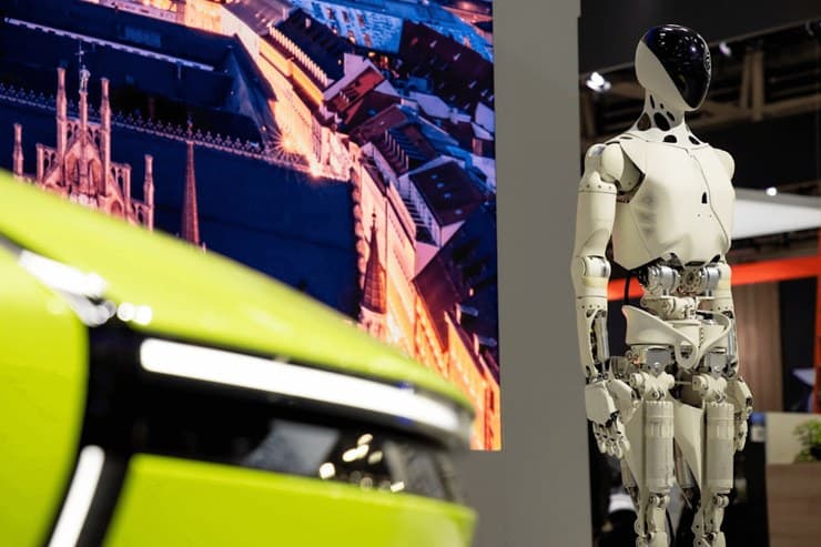 Humanoider Roboter von XPeng neben einem grünen Elektroauto auf einer Messe (Quelle: XPeng)