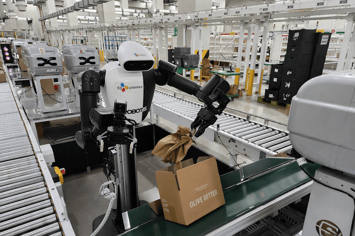 Ein Roboter von CJ Logistics legt Polstermaterial in Versandkartons am Olive-Young-Verteilzentrum Yangji (Südkorea)