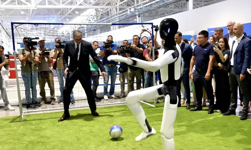 Serbiens Präsident Aleksandar Vučić spielt mit einem Humanoiden in der neuen Fabrik in Šabac