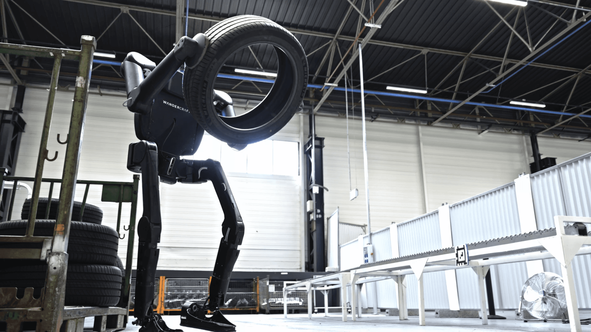 Der Calvin-40 von Wandercraft hebt in einer Werkshalle einen Autoreifen (Herstellerbild)