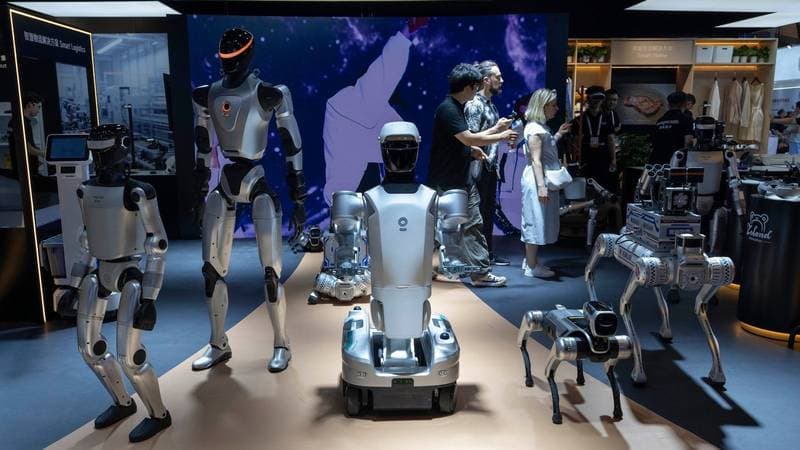 Humanoide und ein Vierbeiner auf einer Roboterschau, Besucher im Hintergrund (Symbolbild)
