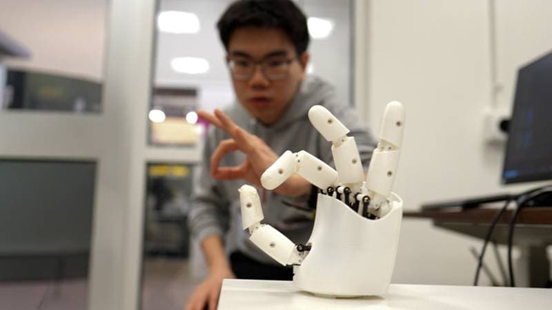 Ein Mensch steuert mit Handbewegungen eine Roboterhand
