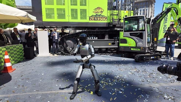 Humanoider Roboter vor einem Bagger auf einer Freiluft-Präsentation (Quelle: Zoomlion)