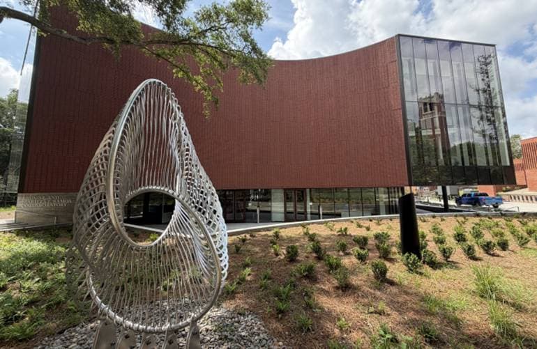 Eine gedruckte, gitterartige Struktur aus mineralischem Material vor einem Gebäude (Symbolbild 3D-Druck im Bau, Quelle: University of Florida)