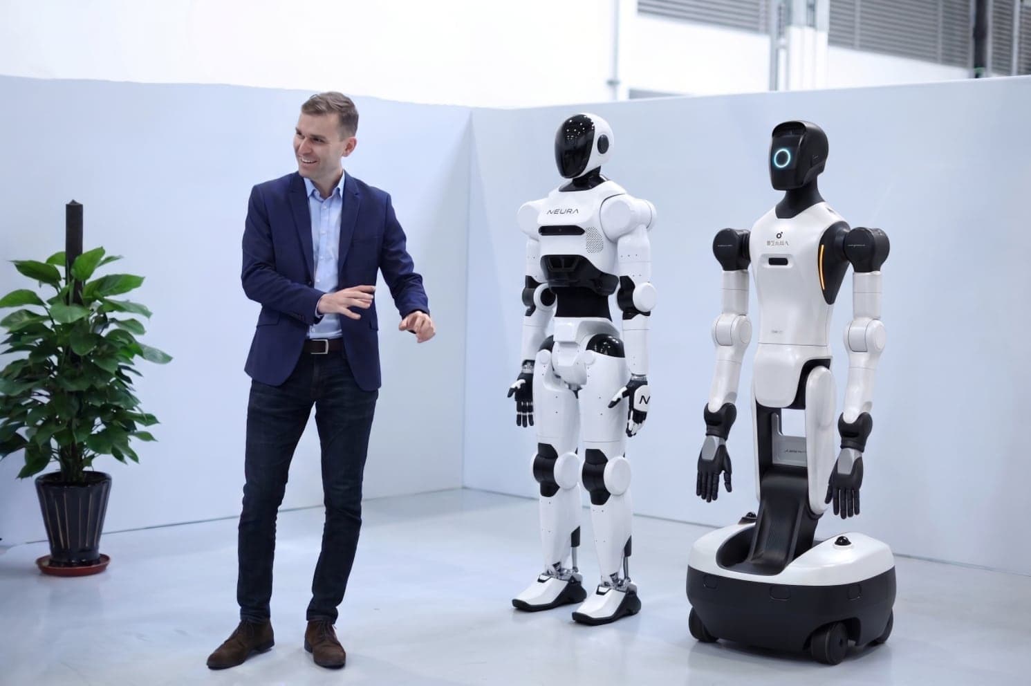 Jakob Waterkamp im Gespräch neben zwei humanoiden Robotern