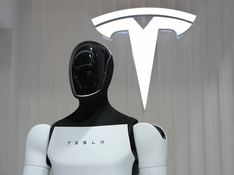 Optimus vor dem Tesla-Logo. Für die Serienfertigung greift Tesla auf Zulieferer zurück, die schon Teile für seine Autos 