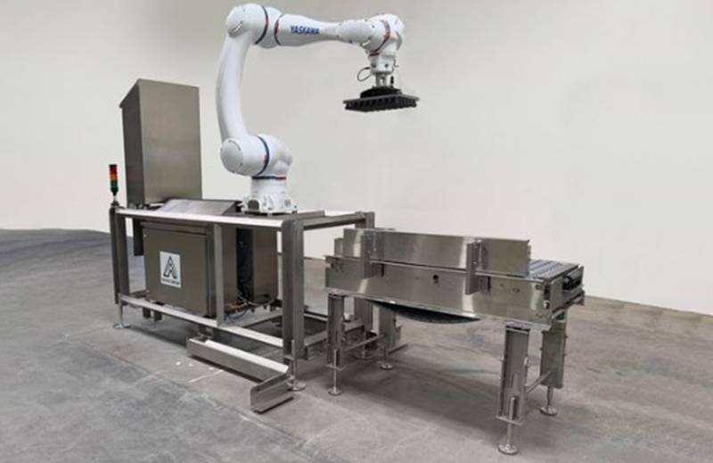 Automatisierte Palettier-Zelle: Ein Cobot-Arm setzt Kartons am Förderband um Symbolbild — Quelle: The Robot Report
