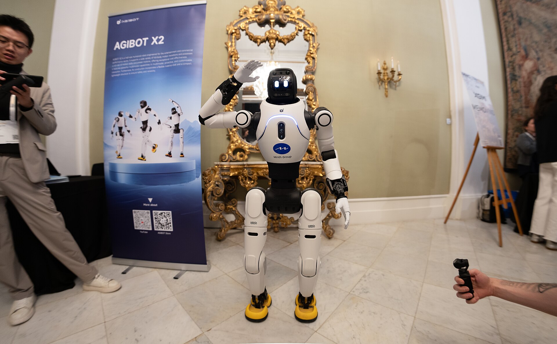 Der AGIBOT X2 auf einer Messe — auf der Brust das Logo der Minth Group, die die Fabrik in Šabac gemeinsam mit AGIBOT bet